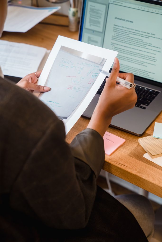 Profissional a preparar notas e documentos junto a um computador antes de uma entrevista digital.